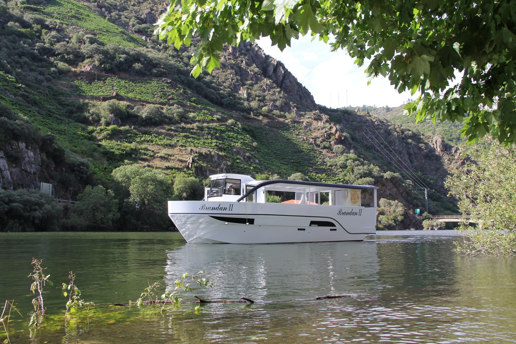 Ein Ausflugsboot auf dem Fluss Sil, im Hintergrund ein steiler Hang.